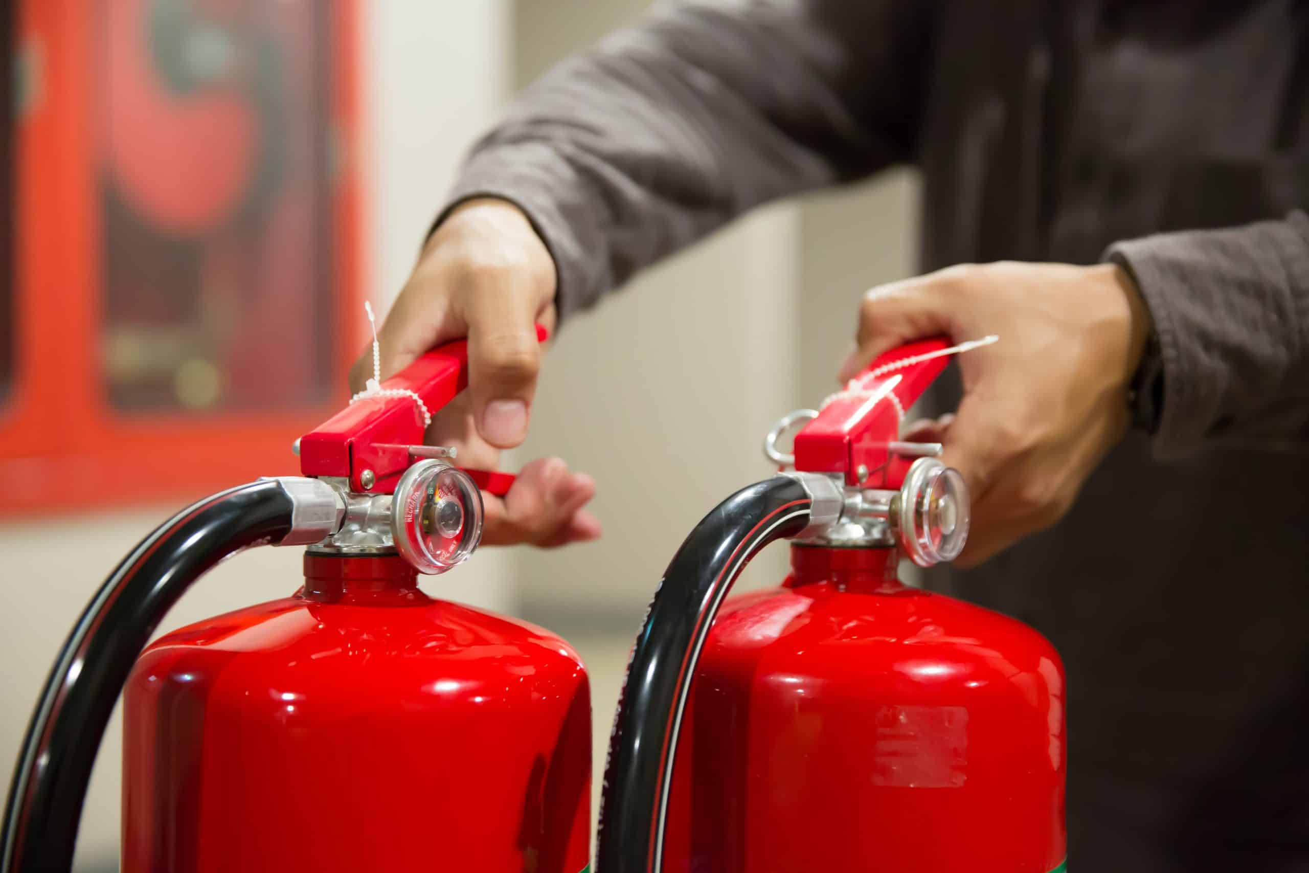 Engineers are checking handle of fire extinguishers.