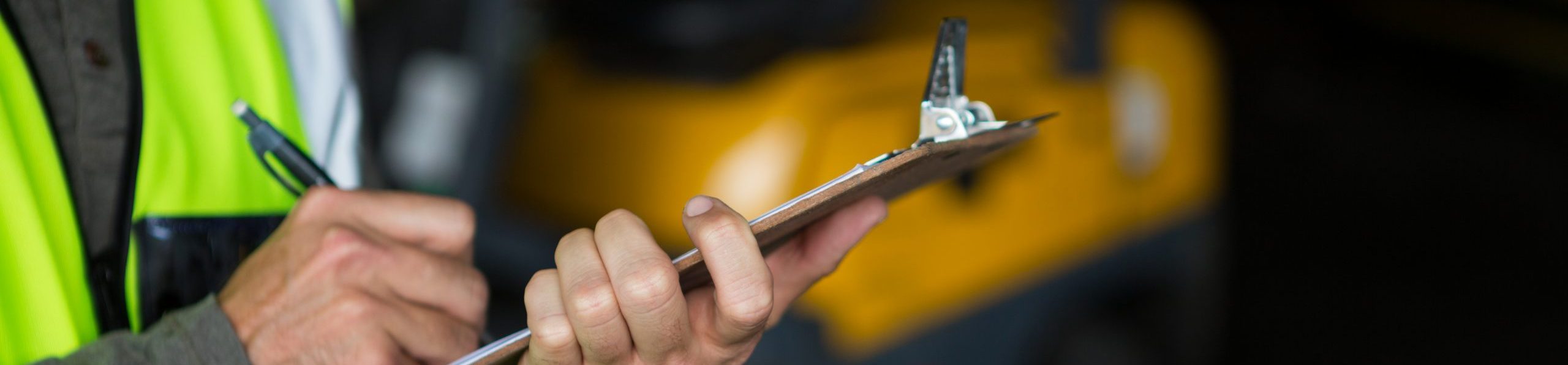 Male worker writing on clipboard taking risk assessment